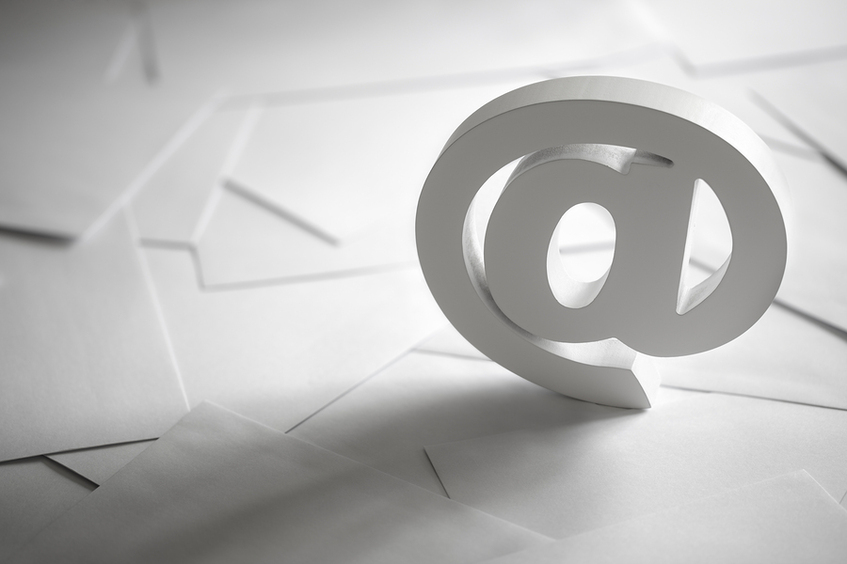 Large @ symbol in white surrounded by blank paper.